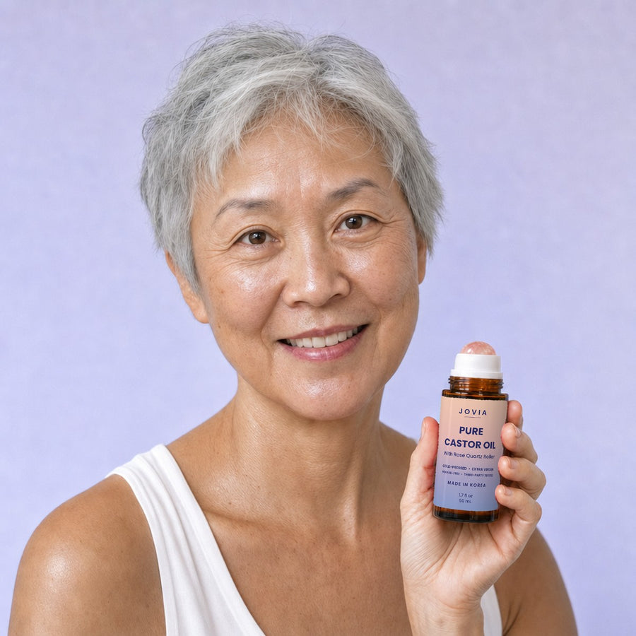 Woman with short grey hair holding Jovia castor oil