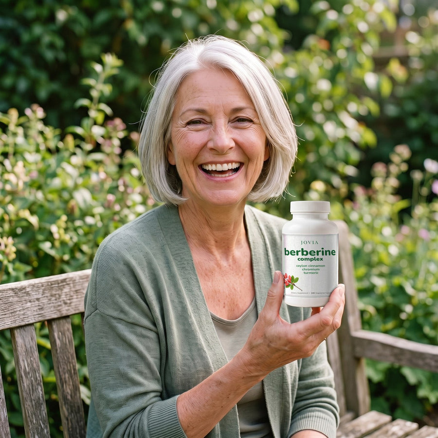 Smiling woman holding Jovia Berberine Complex in her garden