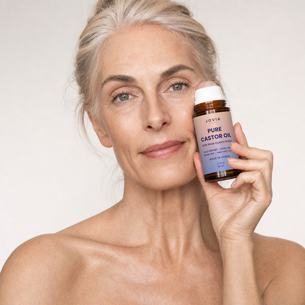Woman holding the Jovia castor oil roller under her eye