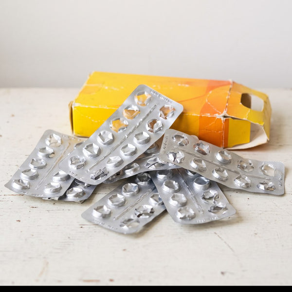 A pile of empty blister packs and a creased pharmacy carton